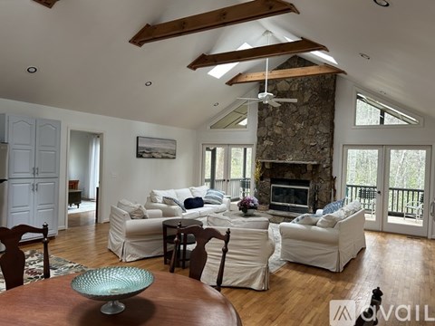 A living room with a stone fireplace and a large couch.