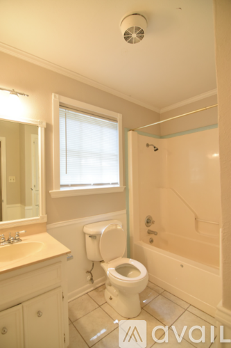 A bathroom with a toilet, sink, and bathtub.