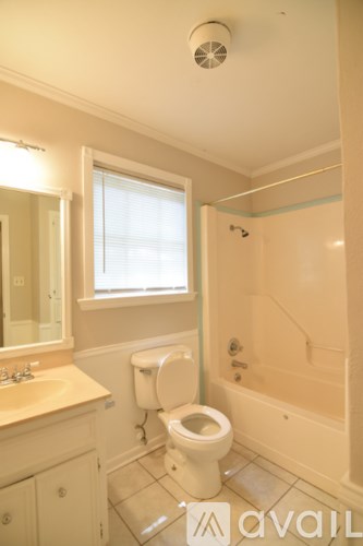 A bathroom with a toilet, sink, and bathtub.