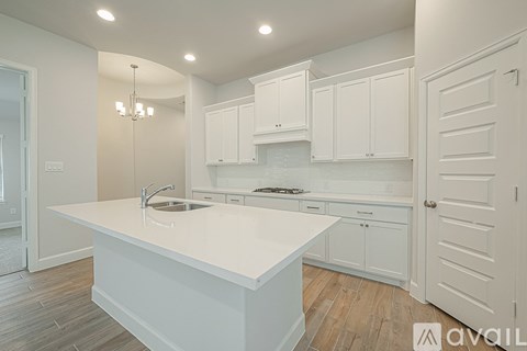 A kitchen with white cabinets and a large island.