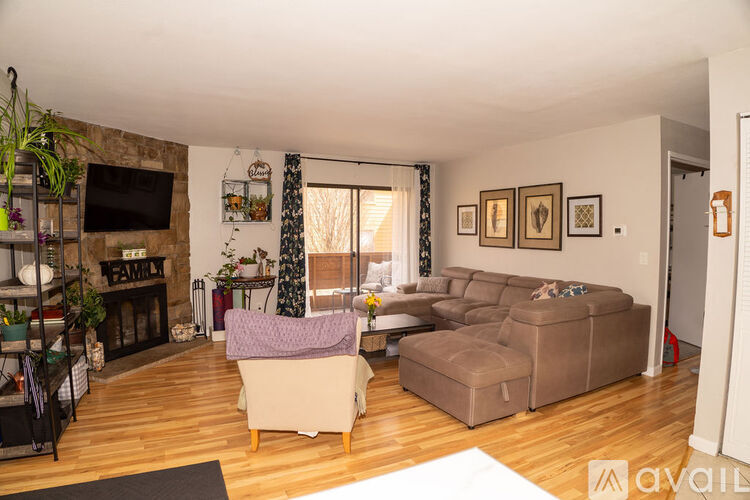 A living room with a couch, chair, and a fireplace.