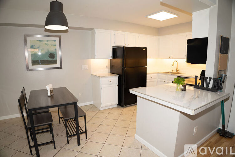 A kitchen with a black table and chairs.
