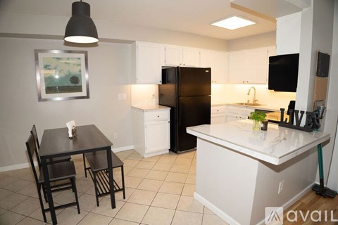 A kitchen with a black table and chairs.