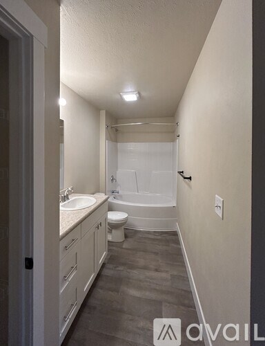 A bathroom with a toilet, sink, and bathtub.
