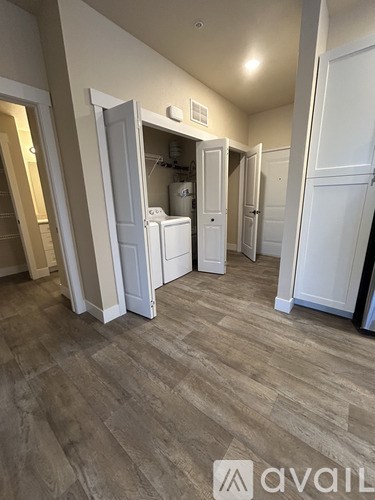A room with a white fridge and a white washing machine.