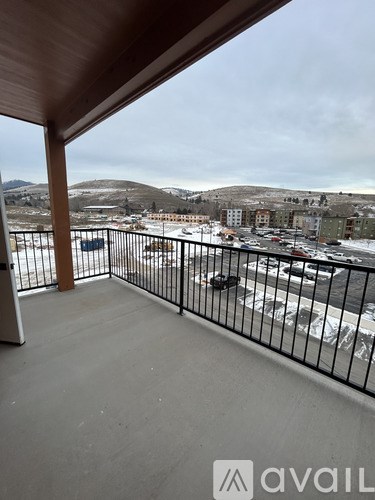 A balcony with a view of a snowy landscape and buildings.