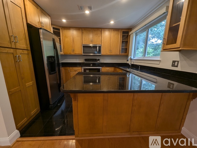 A kitchen with wooden cabinets and a black countertop.