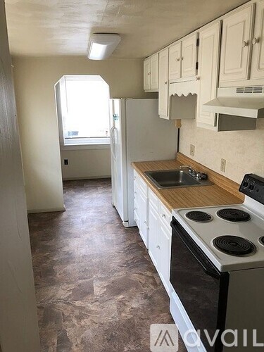 A kitchen with a stove top oven and a refrigerator.