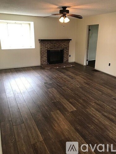 A room with a fireplace and a ceiling fan.