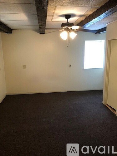 A room with a ceiling fan and a window.
