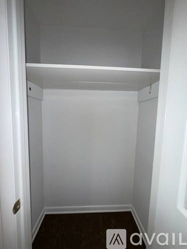 A small, empty room with a door on the left and a wall on the right.