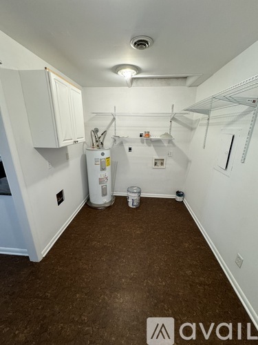 A small, empty room with a white cabinet and a white refrigerator.