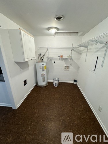 A small, empty room with a white cabinet and a white refrigerator.