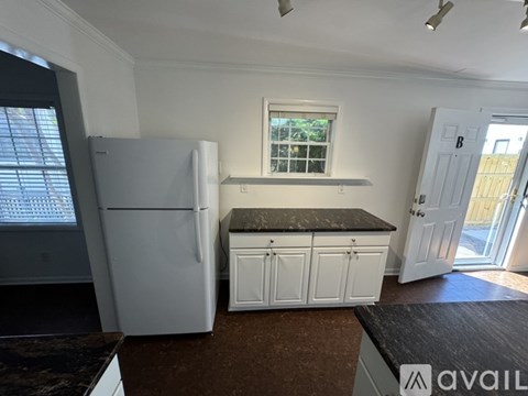 A kitchen with white appliances and cabinets.