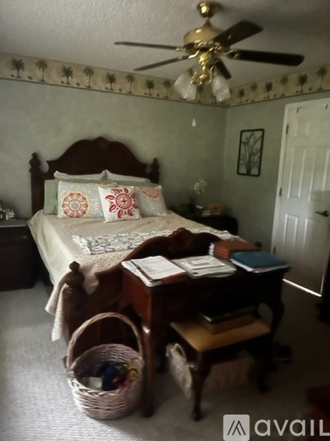 A bedroom with a bed, desk, and chair.