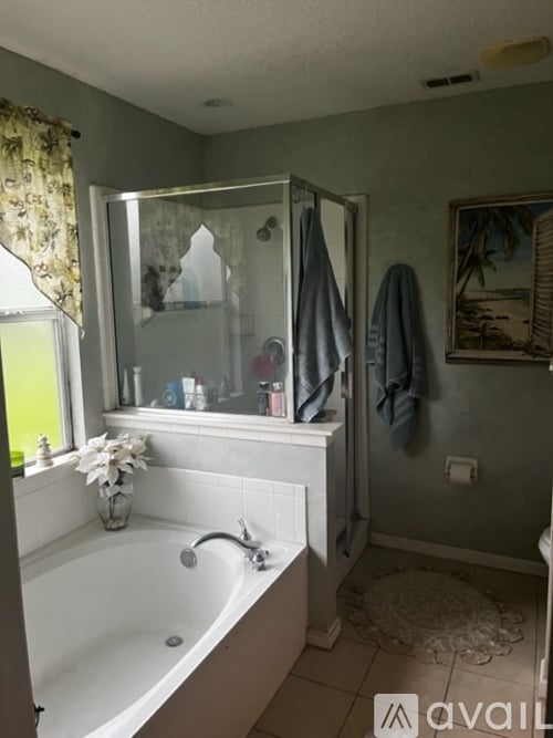 A bathroom with a white bathtub and a glass shower door.