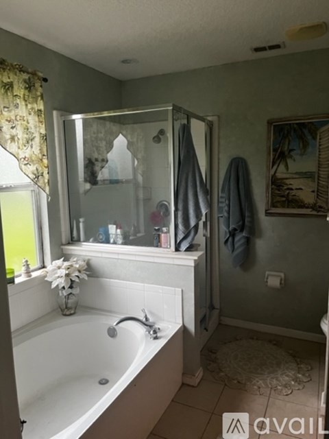 A bathroom with a white bathtub and a glass shower door.
