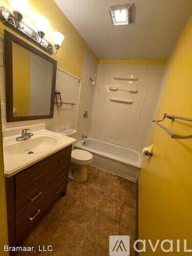 A bathroom with yellow walls and a white toilet.