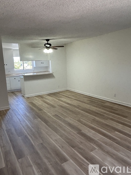 A room with wooden flooring and a ceiling fan.