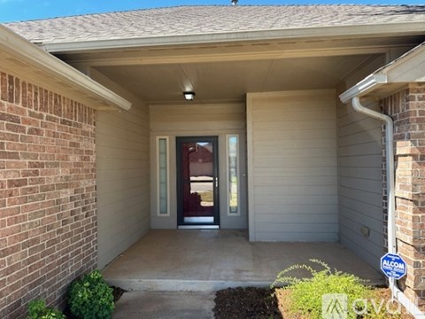 A house entrance with a brick wall and a glass door.