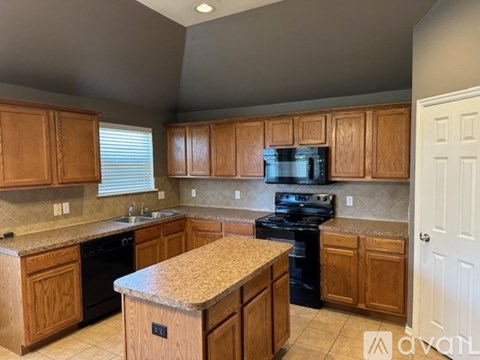 A kitchen with wooden cabinets and granite countertops.