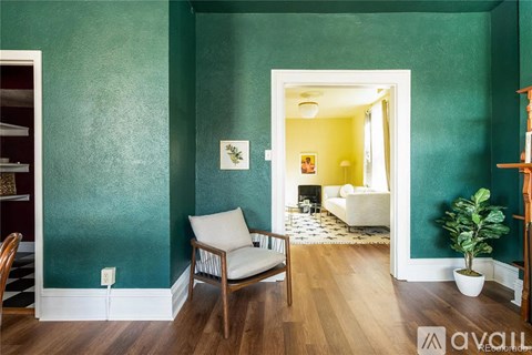 A room with green walls and a white chair.