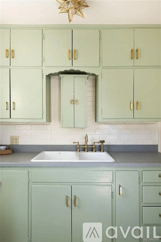 A kitchen with green cabinets and a star decoration above the sink.