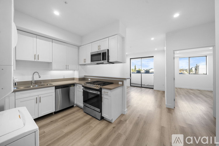 A modern kitchen with white cabinets and stainless steel appliances.