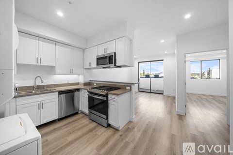 A modern kitchen with white cabinets and stainless steel appliances.