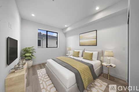 A bedroom with a large bed and a flat screen TV mounted on the wall.