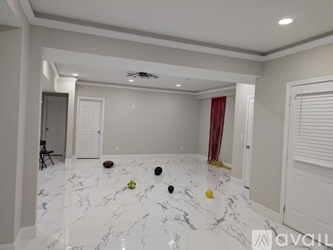A room with white marble flooring and a ceiling fan.