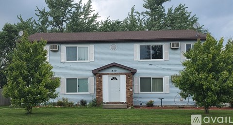 A blue house with a white door and windows is for sale.