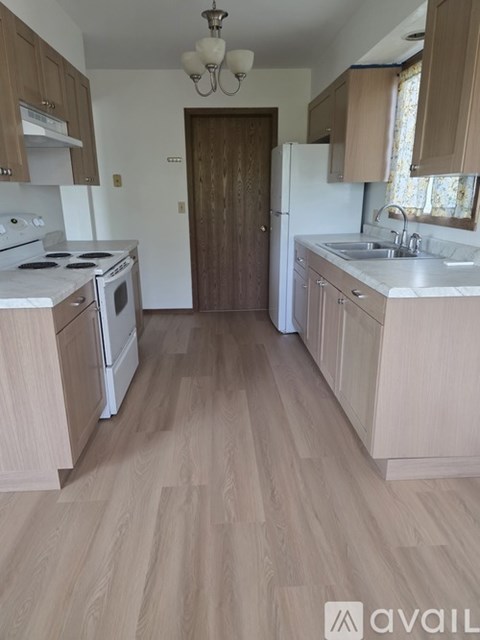 A kitchen with wooden floors and cabinets.