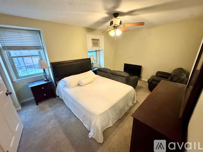 A bedroom with a bed, couch, and television.