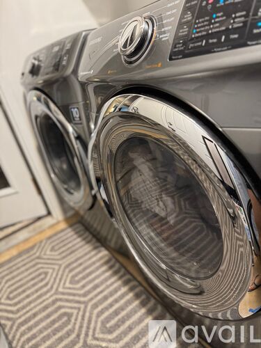 A front-loading washing machine with a digital display and control panel.