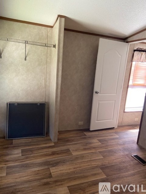 A room with a white door and a flat screen TV.