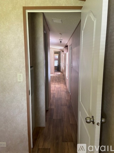 A hallway with a white door on the right.