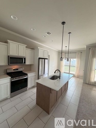 A kitchen with white cabinets and a large island.