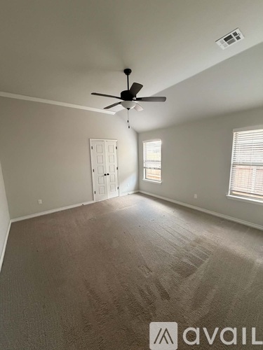 A room with a ceiling fan and a door.