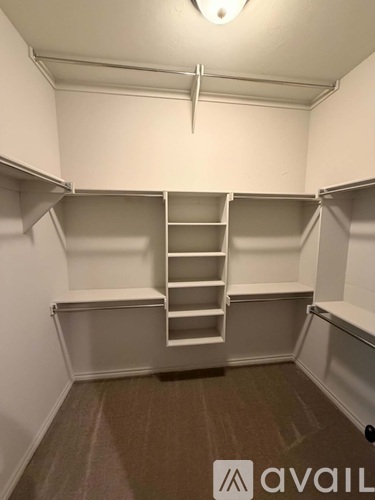 A room with a carpeted floor and a ladder in it.