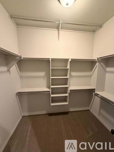 A room with a carpeted floor and a ladder in it.