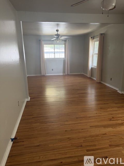 A room with wooden floors and a ceiling fan.