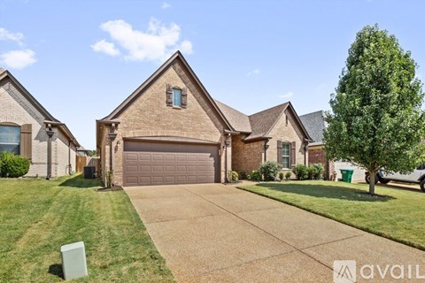A house with a driveway and a tree in front.