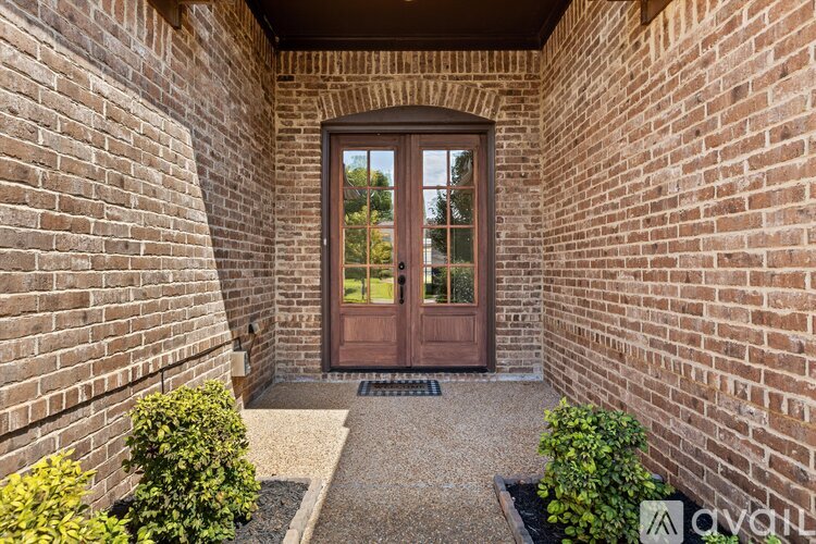A brown door is at the end of a hallway.