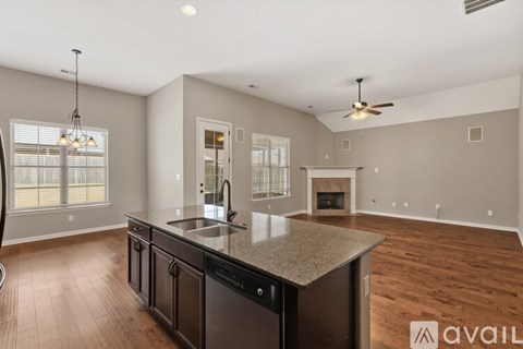 A modern kitchen with dark wood cabinets and a granite countertop.