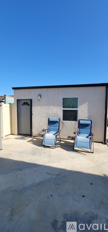 Two chairs are placed on a patio in front of a house.
