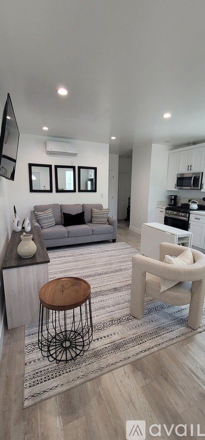 A living room with a grey couch and a white chair.
