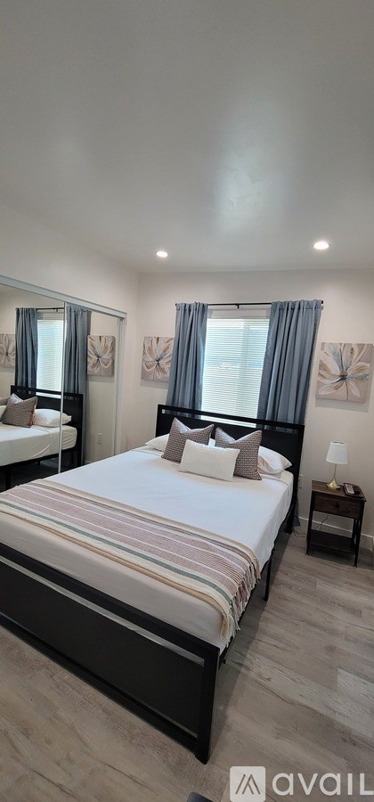 A bedroom with a large bed and a nightstand.