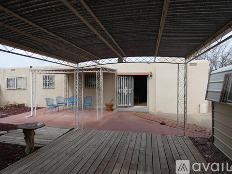 A patio with a table and chairs under a roof.
