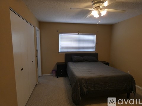 A bedroom with a bed, dresser, and window with blinds.